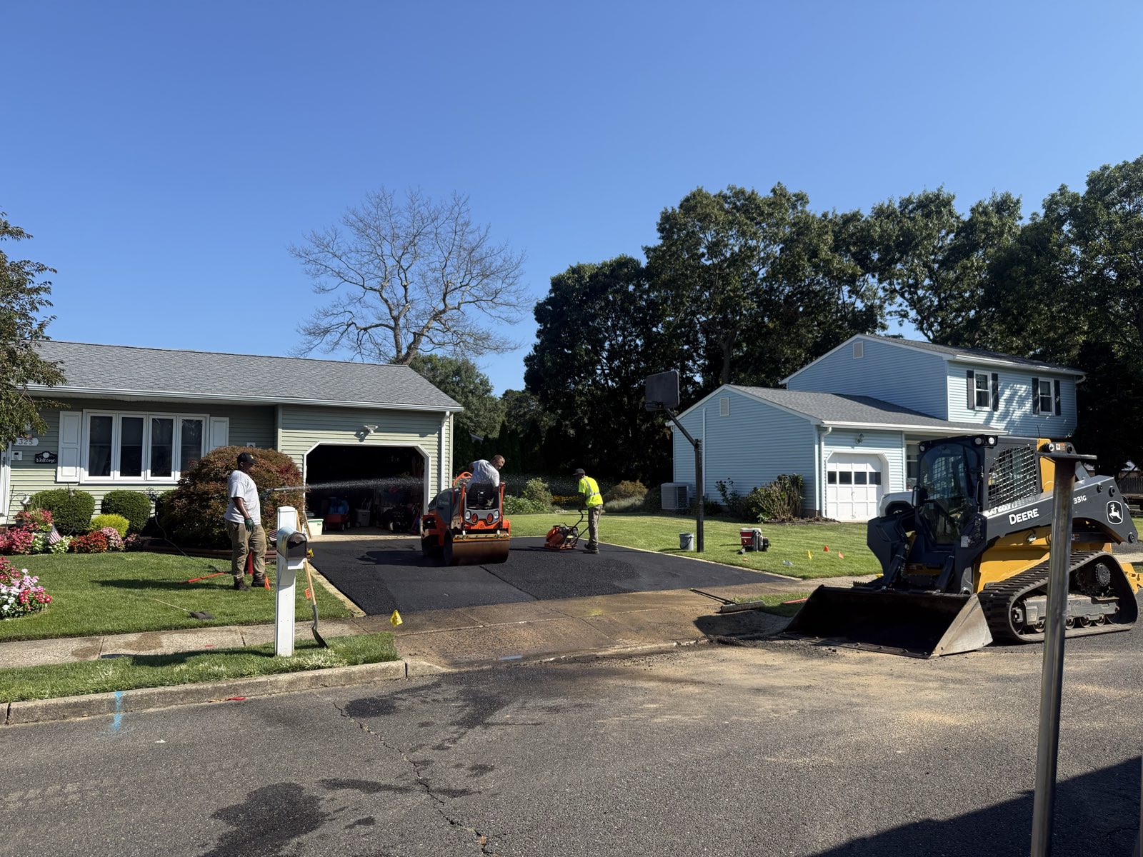 Premier Paving crew compacting a new asphalt driveway with a roller in Ocean County, New Jersey